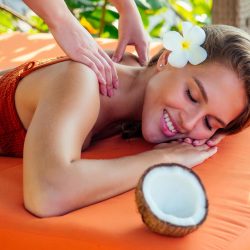 Ayurvedic relaxing massage ,health beauty happy closed eyes woman in spa salon getting massage on the holiday beach.Beautiful girl enjoying day spa resort, lying down on the table treatment procedure