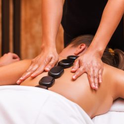 Woman getting thai herbal ball massage treatments in spa.