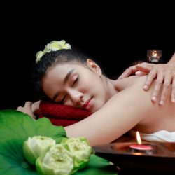 Young beautiful Asian woman having massage in spa environment.